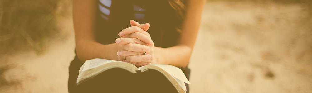 Woman sitting with a bible in her lap.