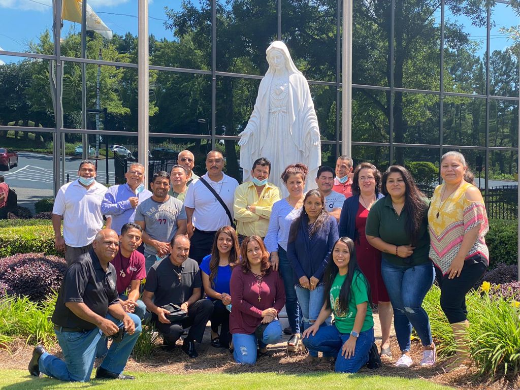 Group standing in front of the statue of the blessed mother located outside of the Chancery office in Smyrna.
