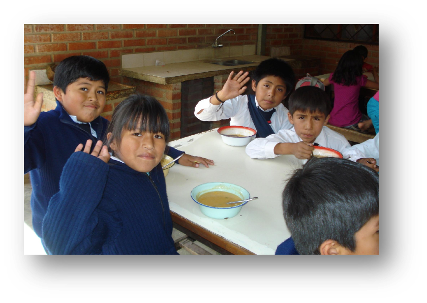 children waving while sitting at a table eating.