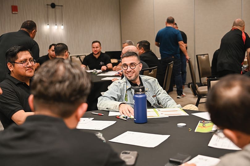 Several men sitting around a table in discussions during a workshop.