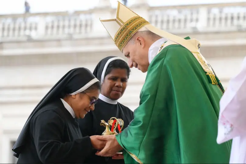 Pope Leo XIV accepts the offertory gifts from two religious sisters during Mass for the Jubilee of Migrants and the Jubilee of the Missions in St. Peter’s Square at the Vatican Oct. 5. CNS photo/Vatican Media