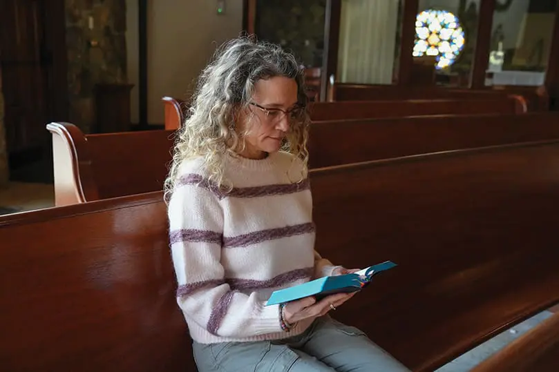 Kimi Nettuno sits in prayer in the empty sanctuary at St. Thomas Aquinas Church in Alpharetta. She prays the Liturgy of the Hours daily, and along with being a spiritual director at the Ignatius House Jesuit Retreat Center, she is a teacher for deacon candidates in the Archdiocese of Atlanta. Many local Catholics draw strength from the prayer practice