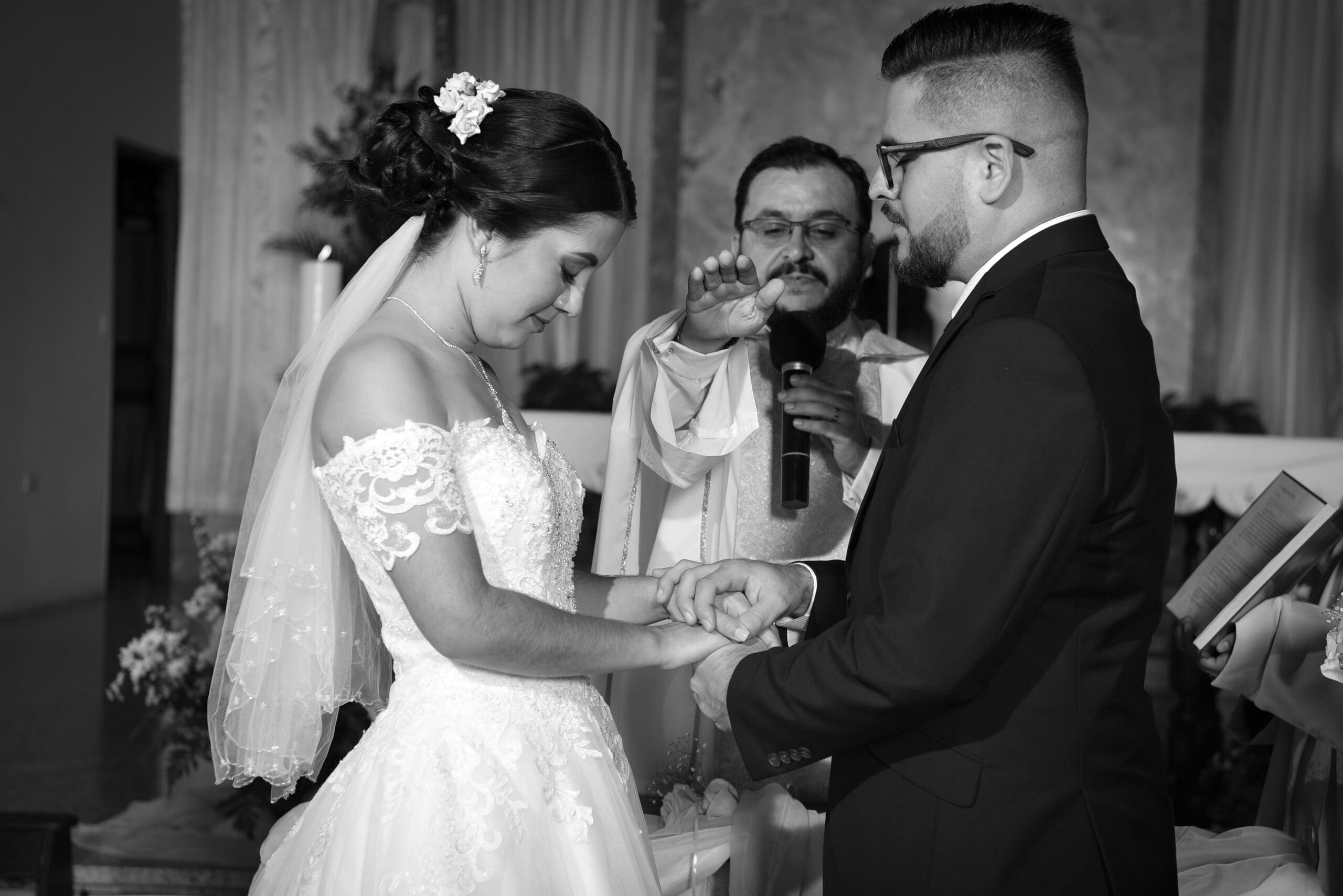 Black and white photo of a couple exchanging wedding vows.