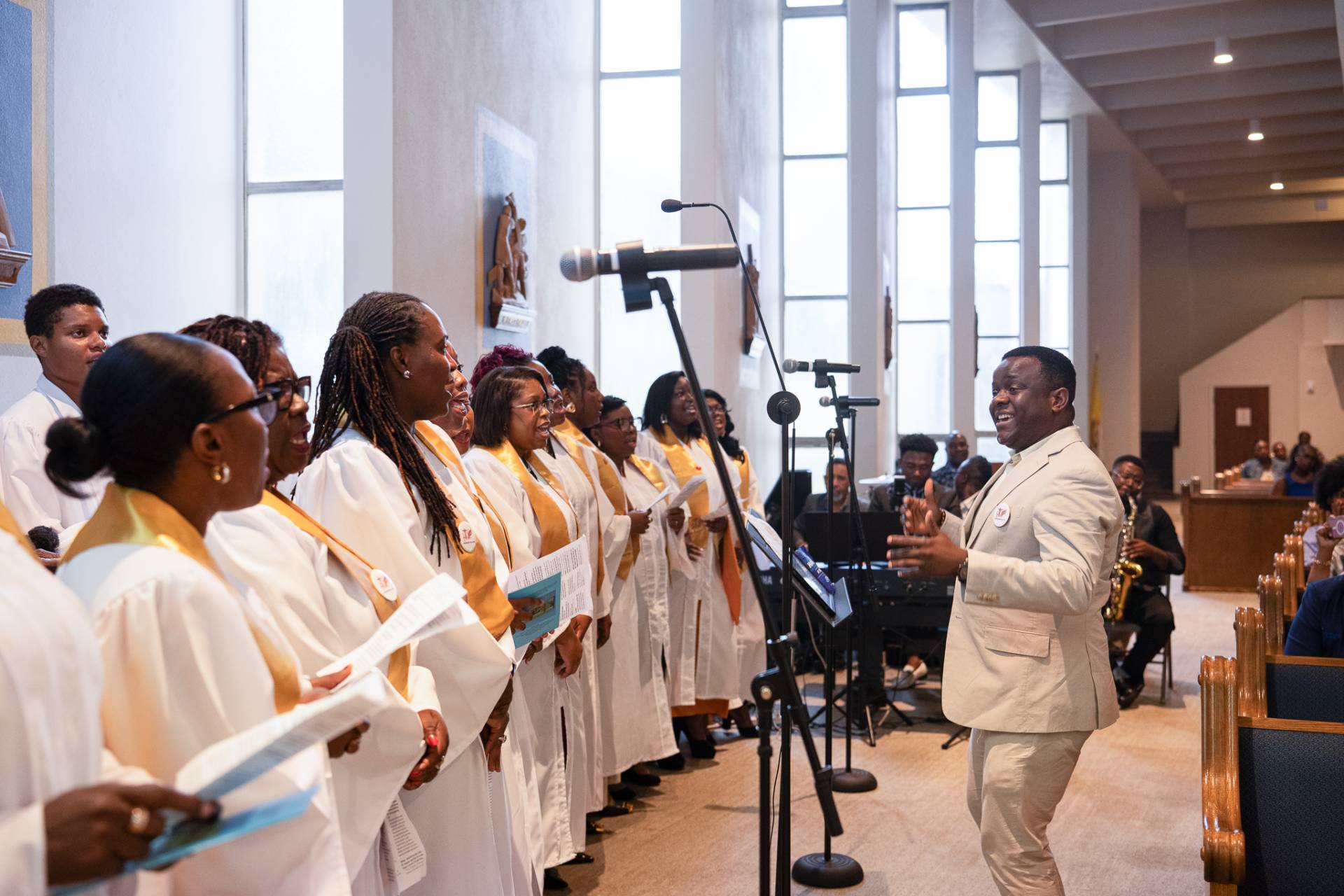 Maestro Dario Clena, left, of Sts. Peter and Paul Catholic Church, conducts the Symphonie de la Foi Haitian choir during the weekly Haitian Community Mass.